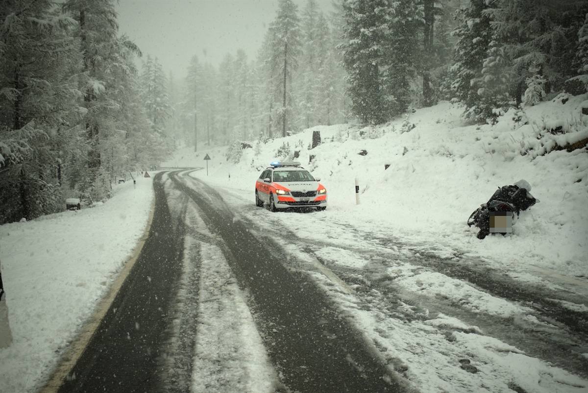 Motorrad liegt auf der schneebedeckten Fahrbahn Polizeifahrzeug ist am Fahrbahnrand sichtbar