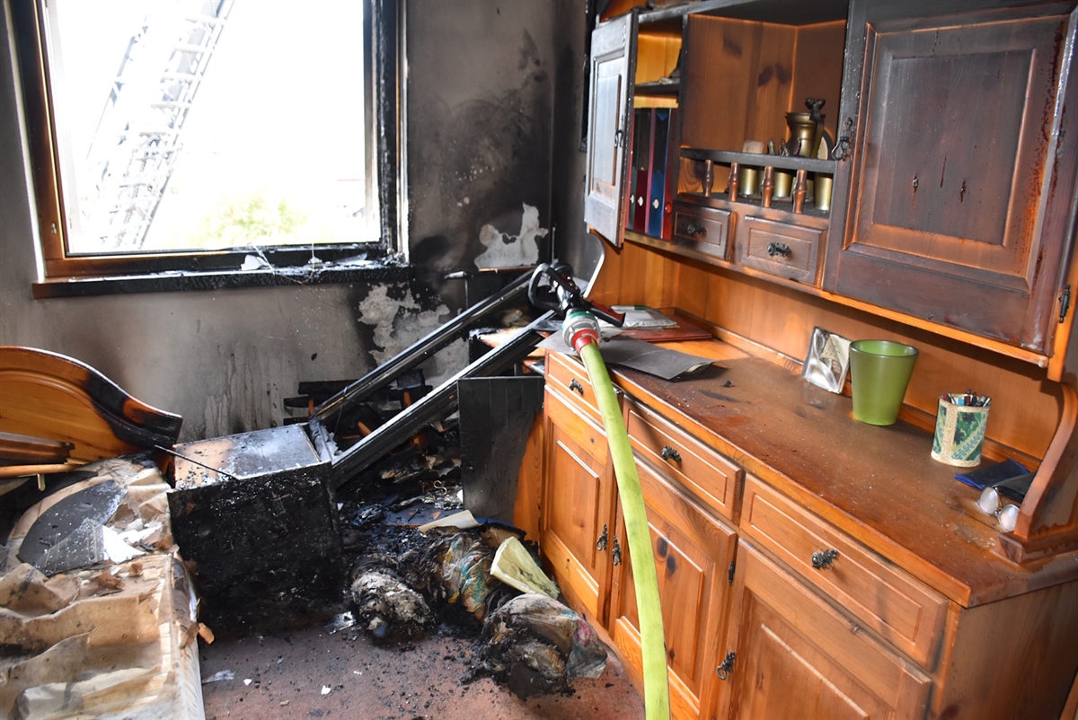 Brandwohnung verkohlte Möbel Feuerwehrschlauch sind auf dem Bild sichtbar 