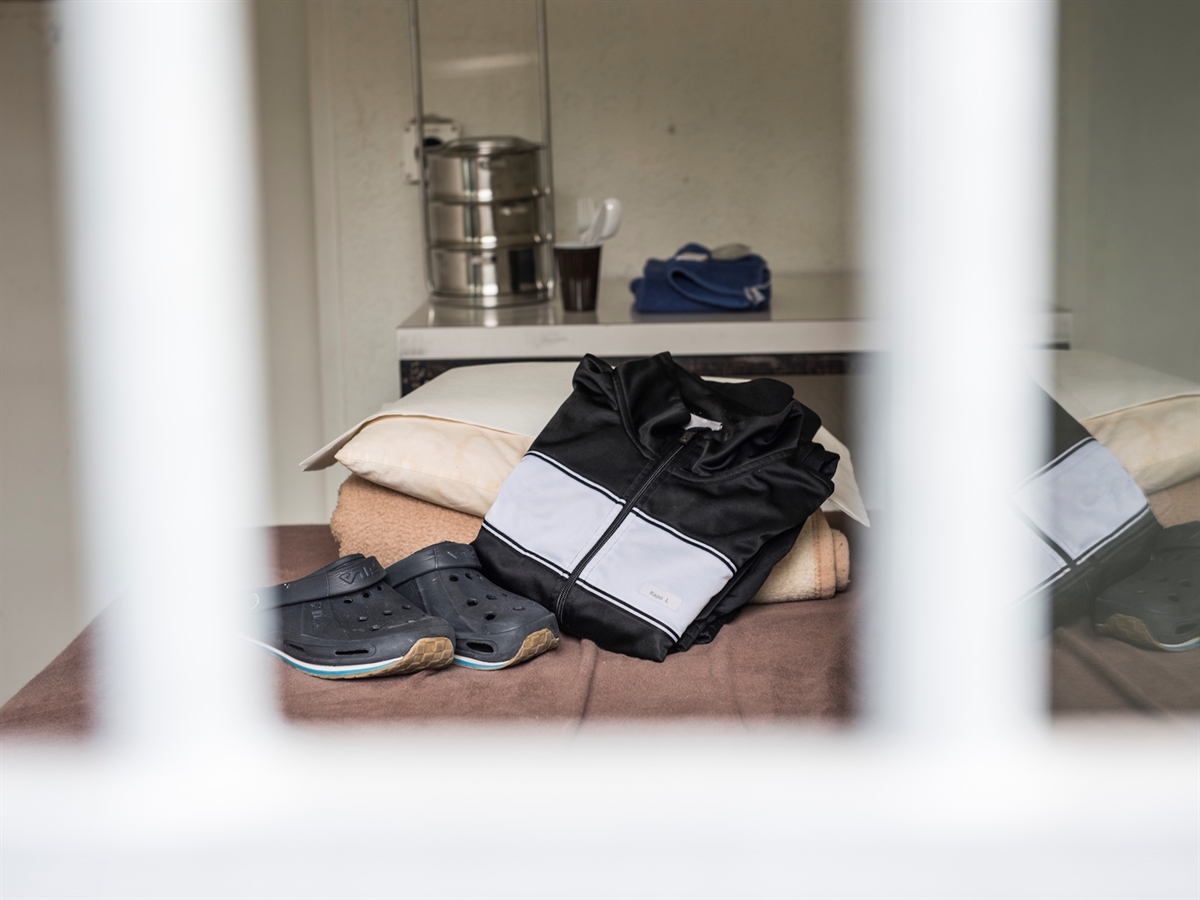 Blick in eine Zelle. Auf dem Bett bereitgestellte Utensilien für eine festgenommene Person.