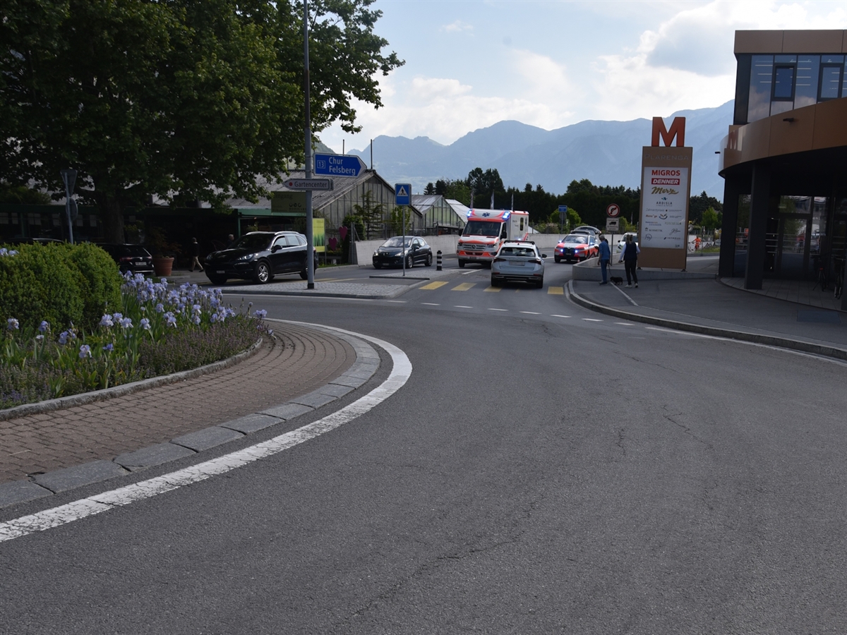 Der Verkehrskreisel an dessen Ausgang das Auto auf dem Fussgängerstreifen steht. Im Hintergrund Berge.