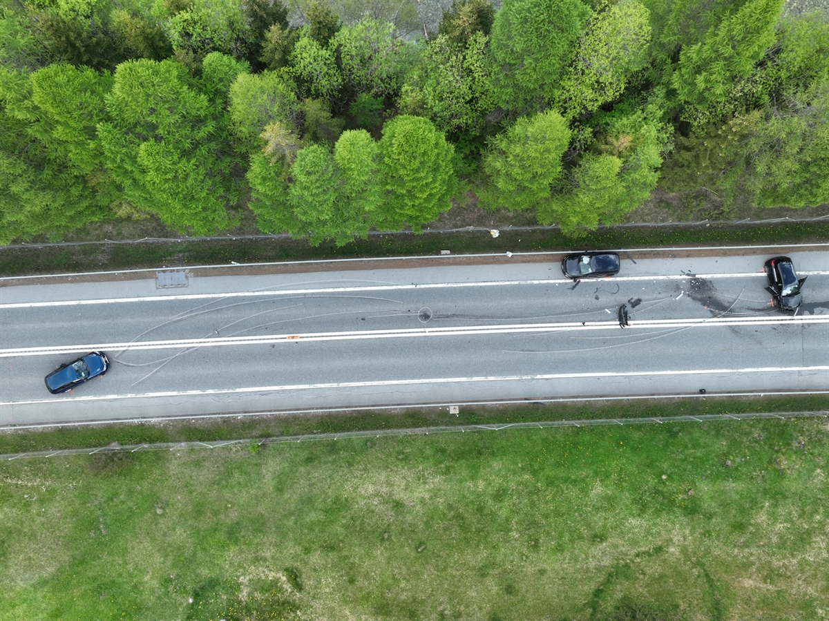Luftaufnahme auf den Unfallort mit den beteiligten Fahrzeugen in Endlage. Markierte Kollisionsspuren.