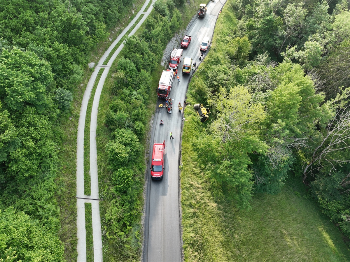 Drohnenaufnahme auf die Unfallstelle. Diverse Einsatzfahrzeuge sowie die auf der Seite liegende Walze. 