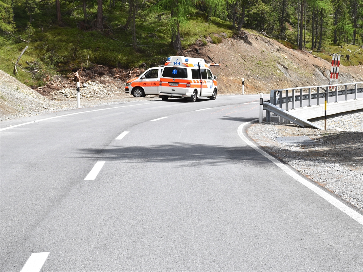 Die Ofenbergstrasse mit der Rechtskurve. Links in der Kurve stehen ein Ambulanz- sowie ein Polizeifahrzeug.