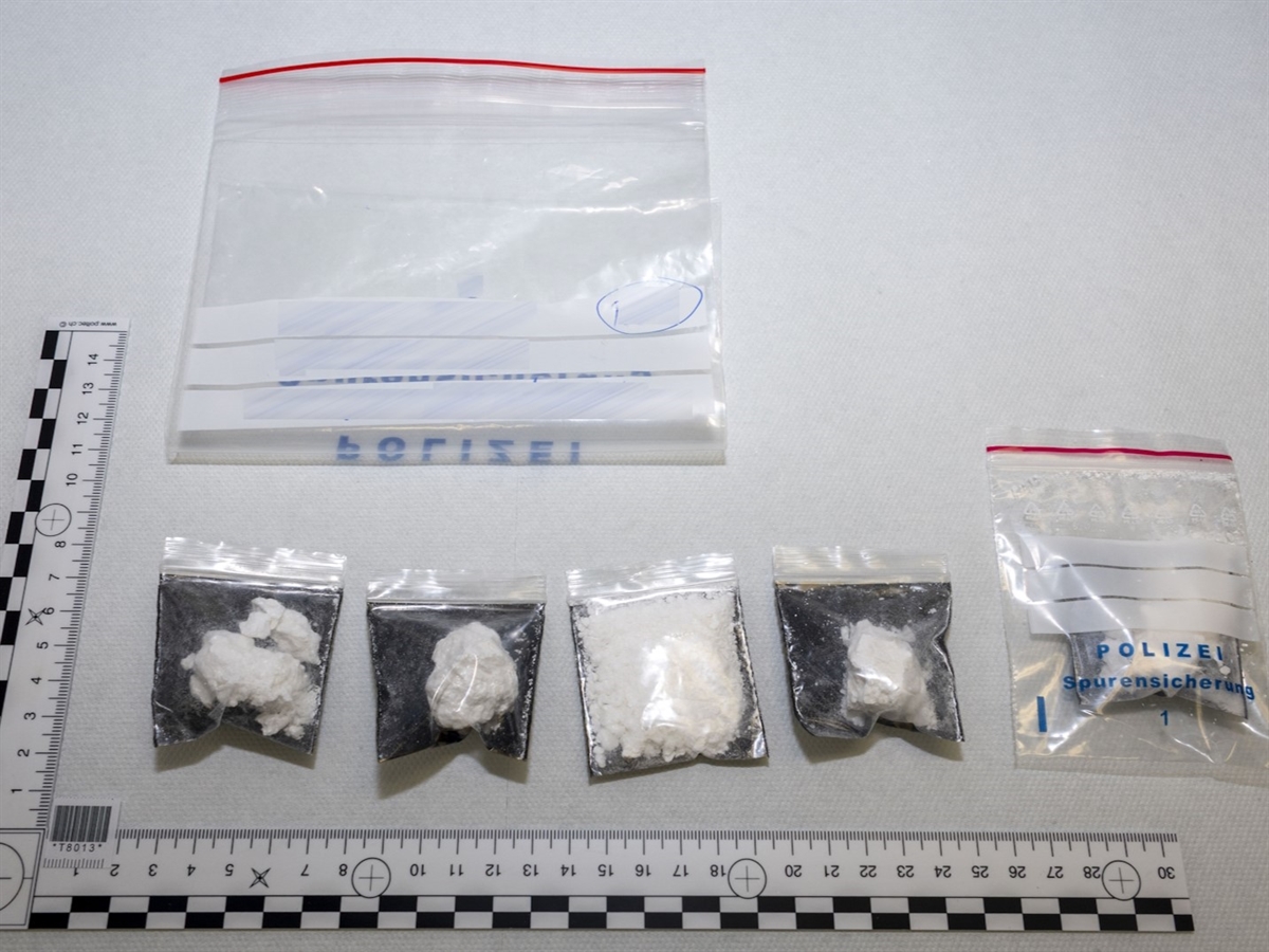 Sechs wiederverschliessbare Kunststoffbeutel in unterschiedlicher Grösse. Fünf davon mit Kokain befüllt. Umrahmt von zwei Massstäben.