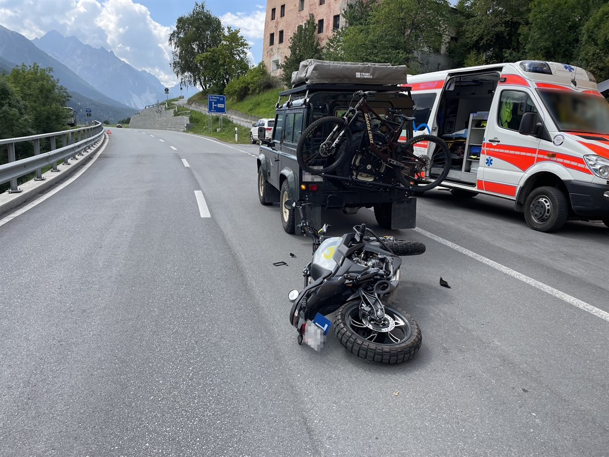 Das Unfallauto in Fahrtrichtung in Senz. Dahinter liegt das Motorrad des Lernfahrers. Rechts neben den beiden Fahrzeugen steht der Rettungswagen auf einem Ausstellplatz.