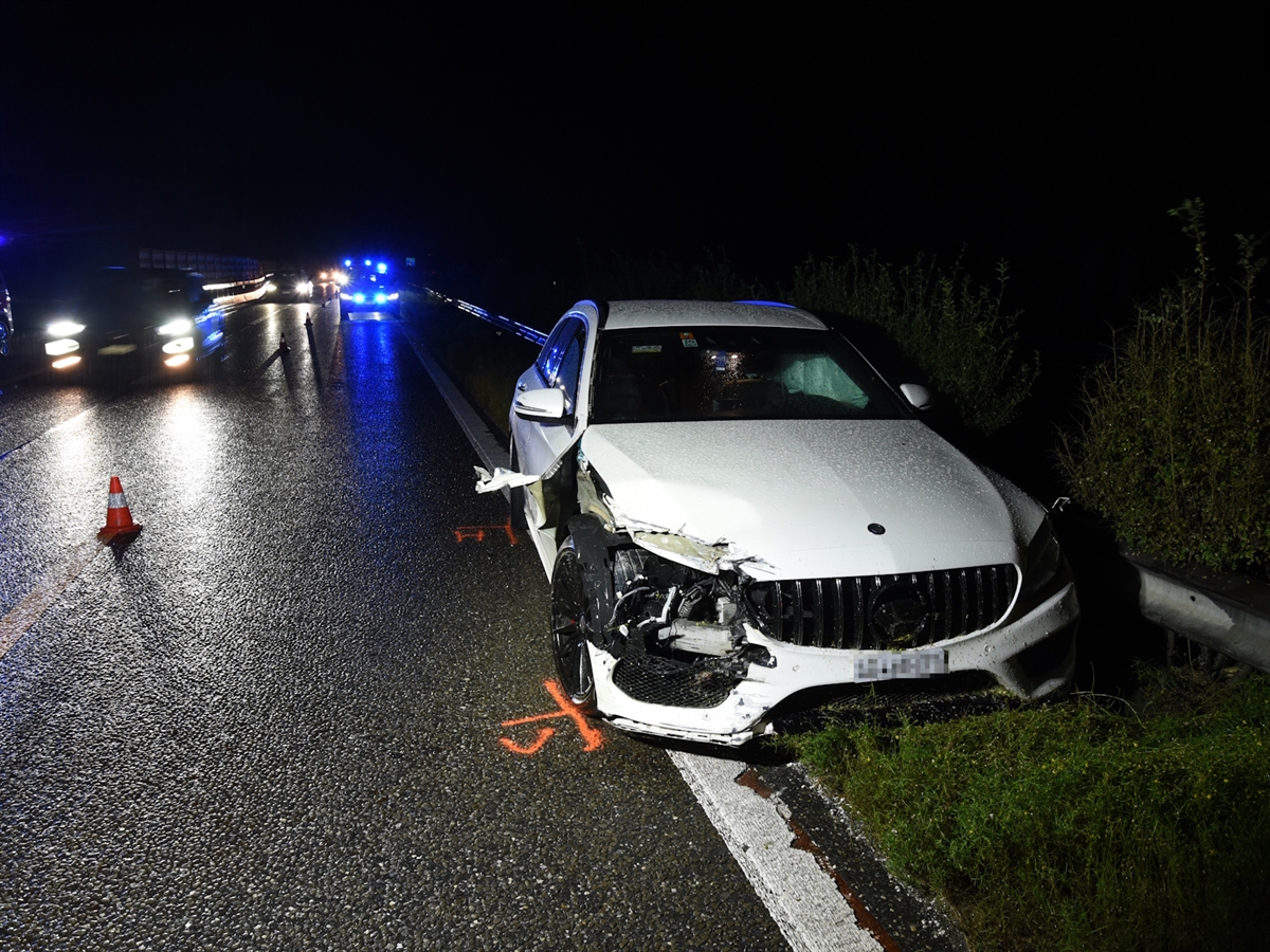 Das überholende Auto steht am Mittelstreifen neben der Mittelleitplanke und ist auf beiden Fahrzeugseiten beschädigt.