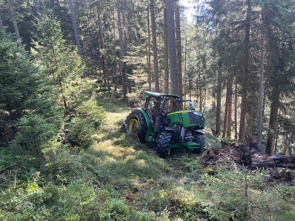 Der total beschädigte Traktor. Im Hintergrund Bäume.