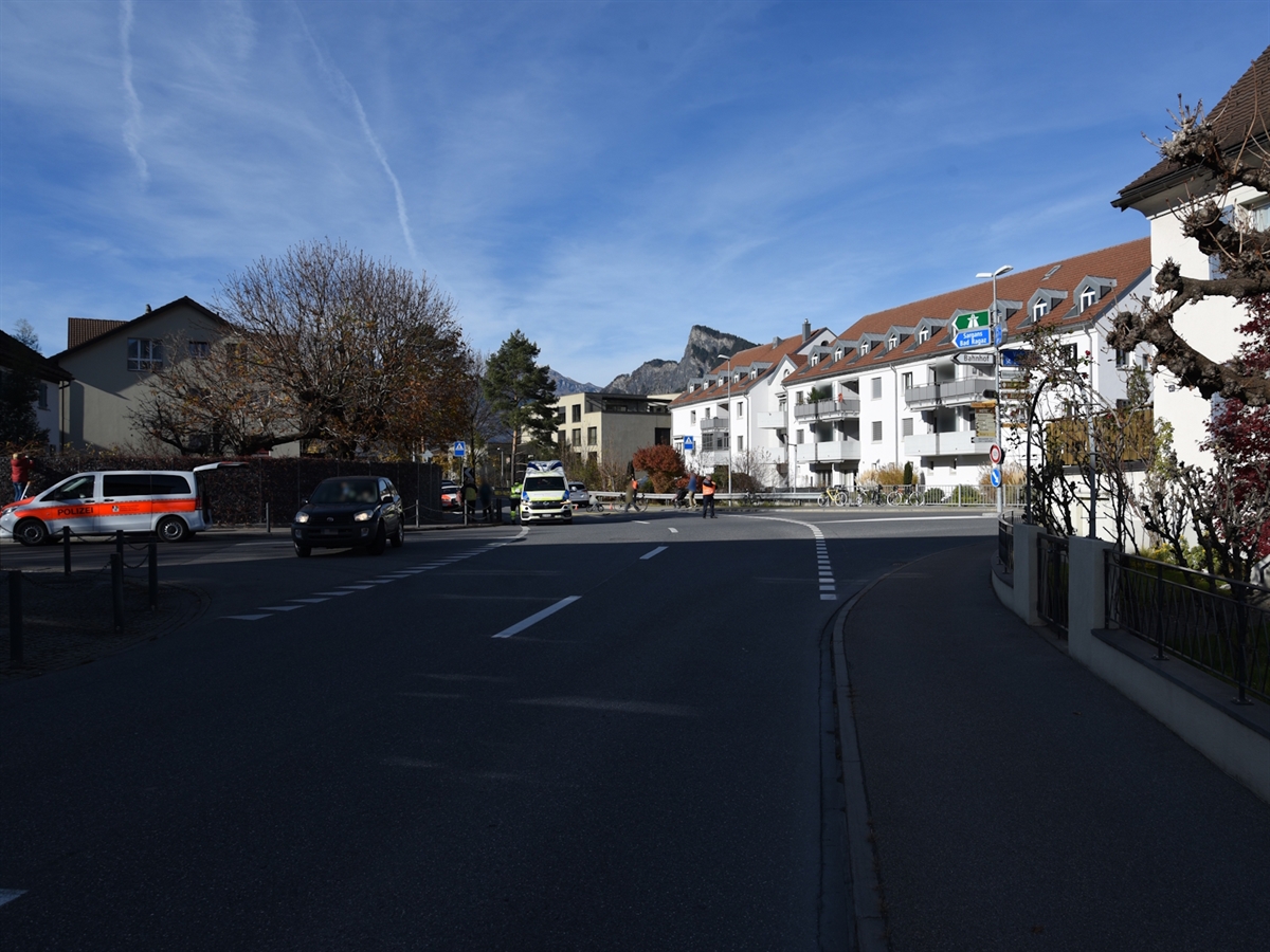 Die Verzweigung in Maienfeld wird rund herum mit Häuser flankiert. Auf der Fahrbahn stehen Einsatzfahrzeuge der Polizei und der Rettung. Ein Polizist regelt auf der Kreuzung den Verkehr.