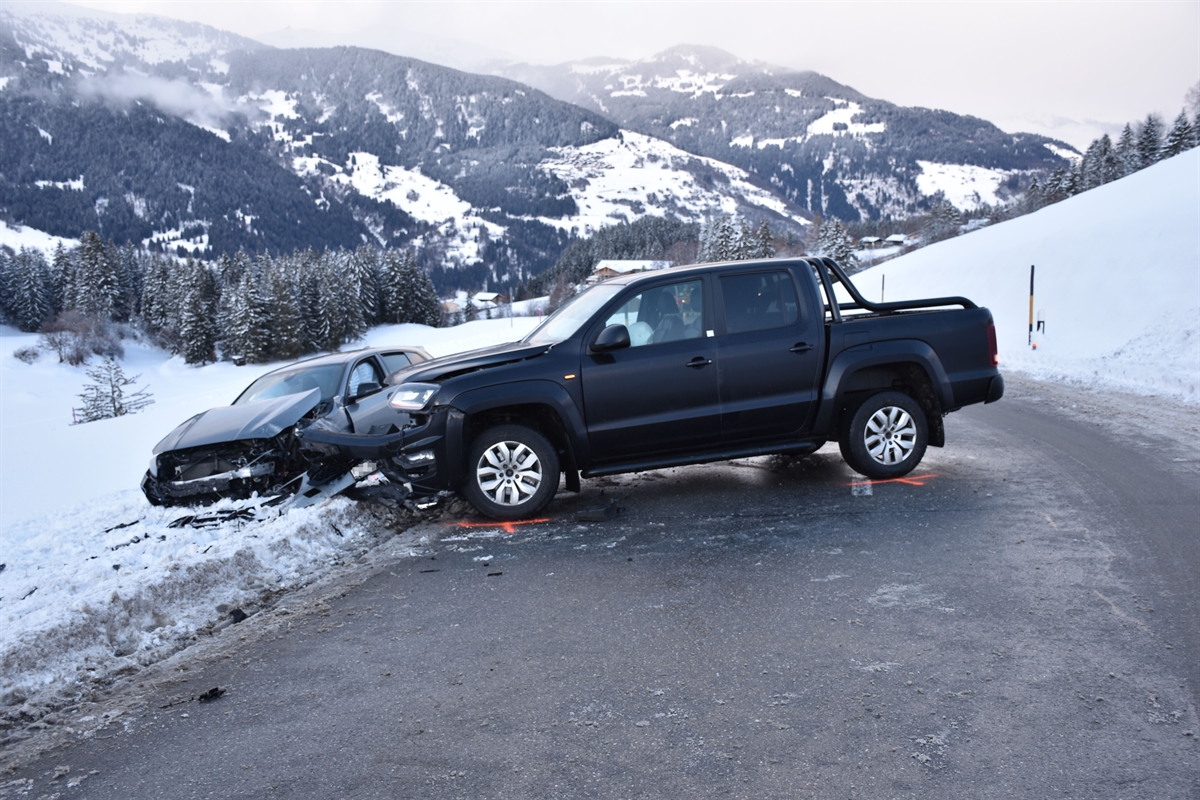Strassenverlauf in Obersaxen bei der Unfallstelle. Es sind beide beteiligten beschädigten Fahrzeuge zu erkennen. 