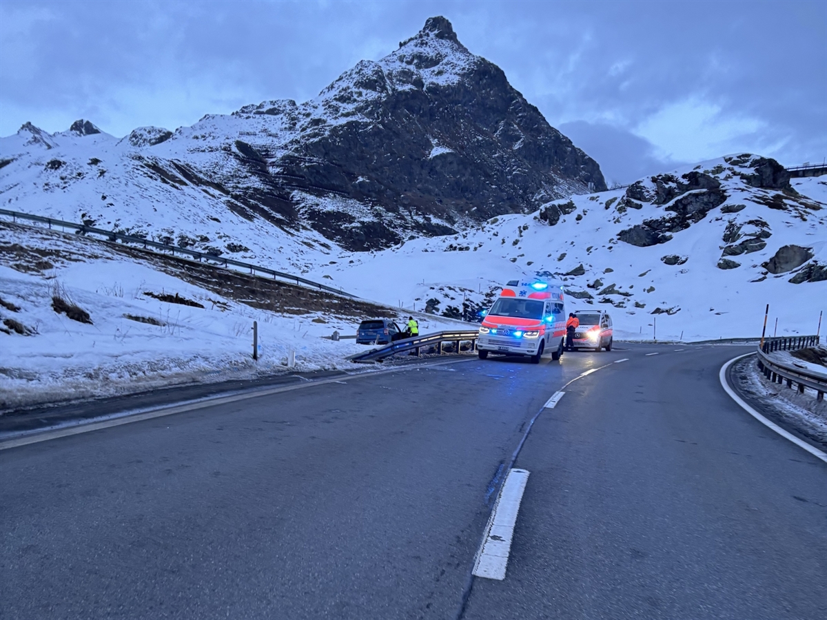 Die Julierpassstrasse N29 vor winterlicher Bergkulisse. Links auf der Fahrbahn ein Rettungswagen, ein Patrouillenwagen. Links daneben im Schnee ist das Unfallauto zu erkennen.