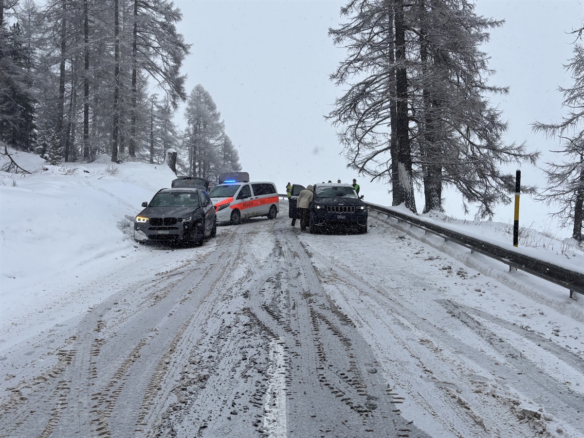 Die beiden Unfallautos auf verschneiter Strasse. Dahinter ein Polizeiauto.
