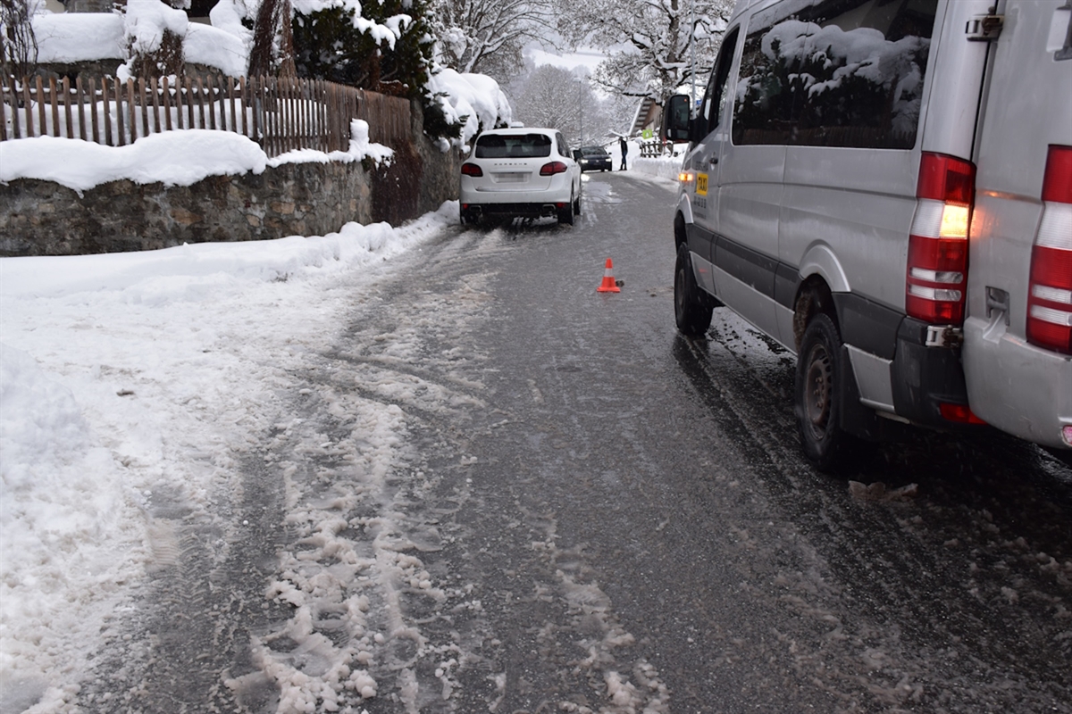 Ein stehender Schulbus im Vordergrund und etwas weiter hinten ein Auto.