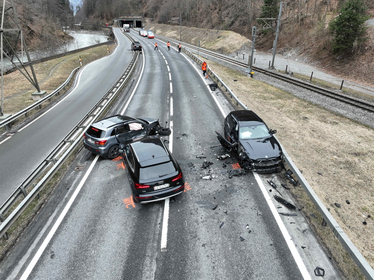 Strassenverlauf der Nationalstrasse N28 bei der Unfallstelle in Richtung Landquart gesehen. Im Vordergrund auf der Fahrbahn sind drei beteiligte Autos, im Hintergrund noch das vierte beteiligte Fahrzeug zu erkennen. 