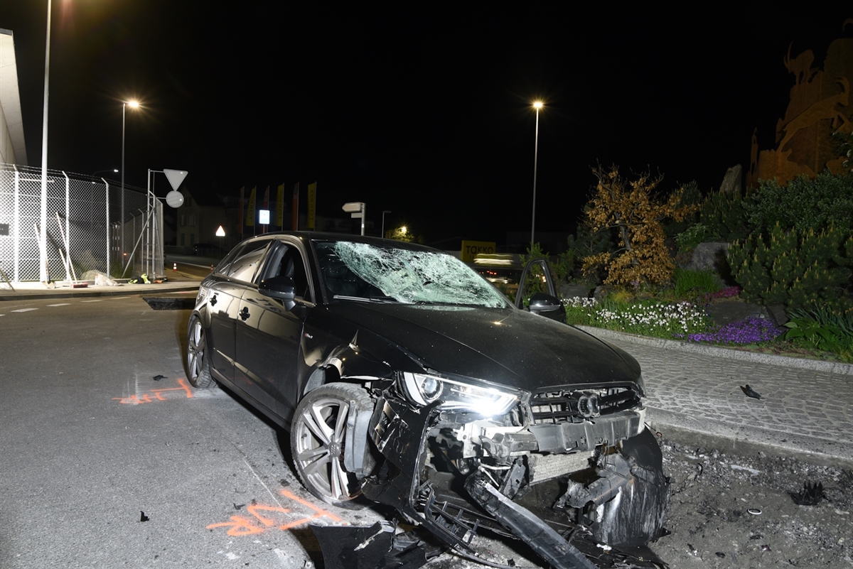 Stark beschädigtes Auto steht im Kreisel.