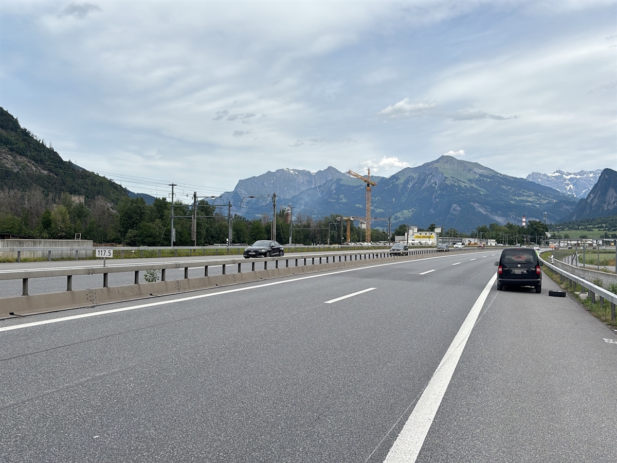 Die Autobahn. Rechts auf dem Pannenstreifen das Verursacherfahrzeug. Es hängt links runter, rechts davon das zuvor verlorene Rad.
