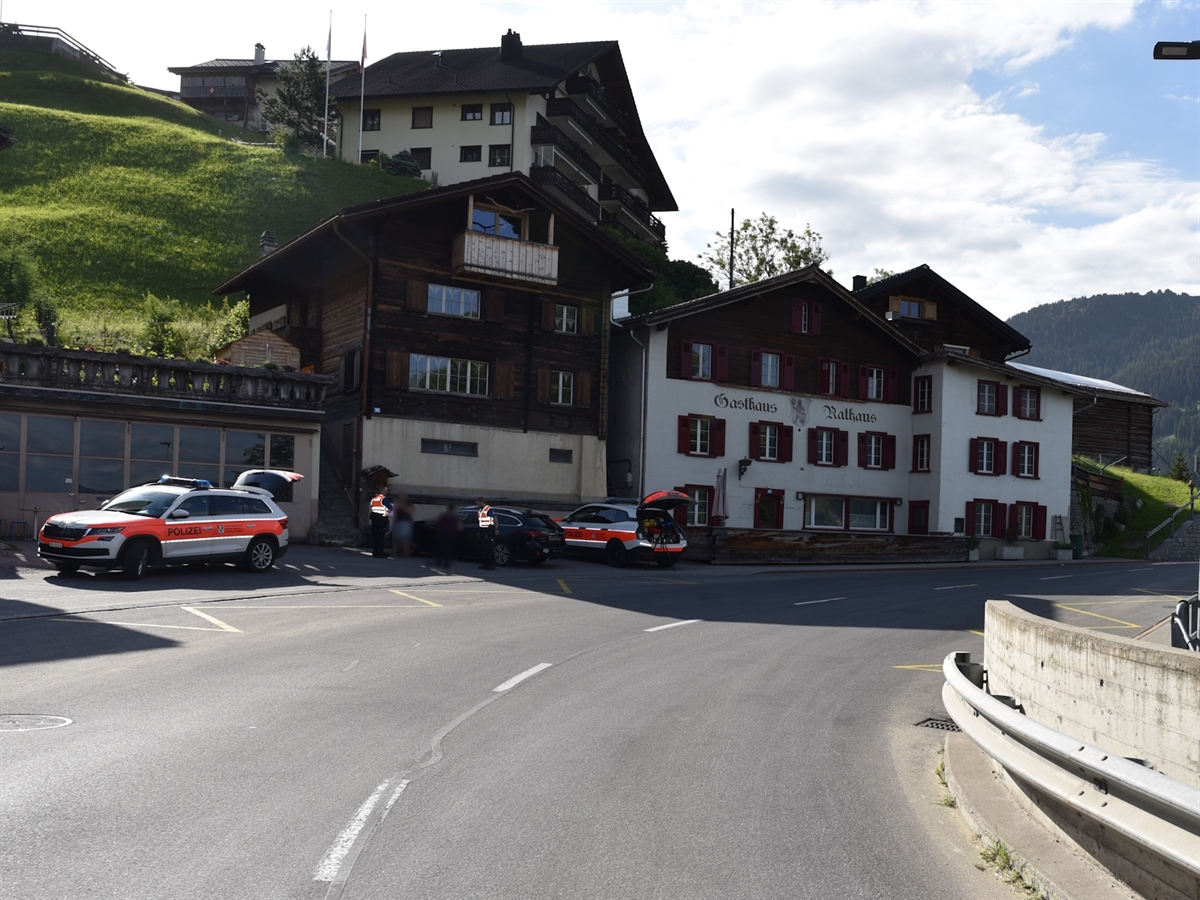 Die Unfallörtlichkeit aus Sicht des Automobilisten. Die Fahrbahn wird rechts von einer Leitplanke und einer 1.10 Meter hohen Betonmauer begrenzt. Auf der linken Strassenseite auf einem Parkplatz stehen zwei Polizeifahrzeuge sowie das beteiligte Auto.