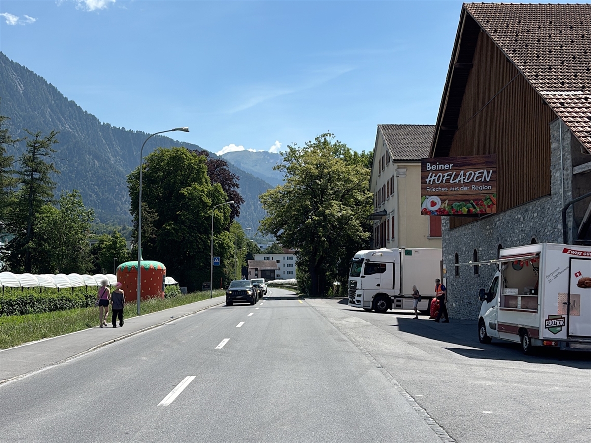 Übersichtsaufnahme der Unfallstelle. Rechts der Strasse ein Vorplatz und Gebäude.