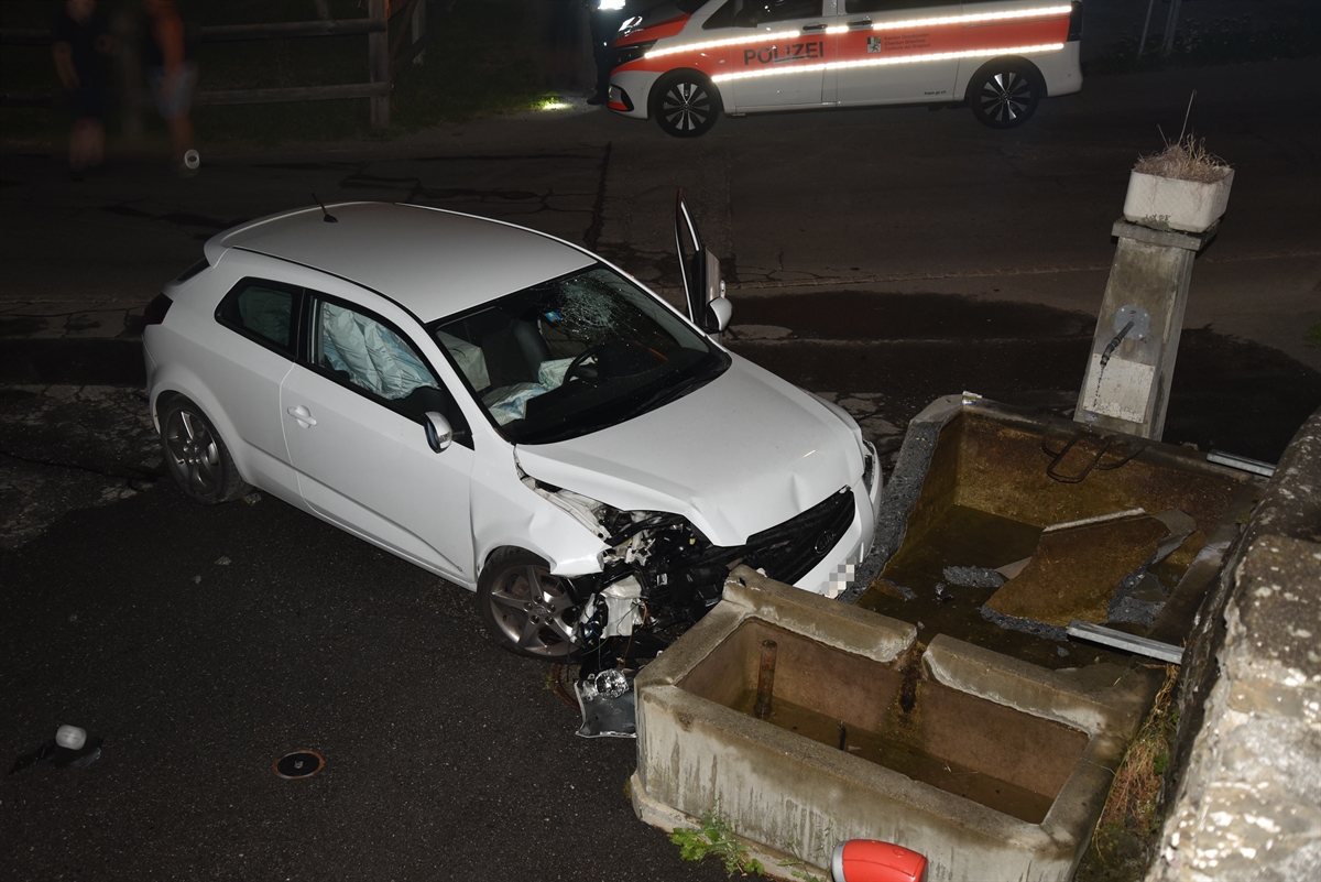Beschädigter Pw am Brunnen, Polizeiauto im Hintergrund