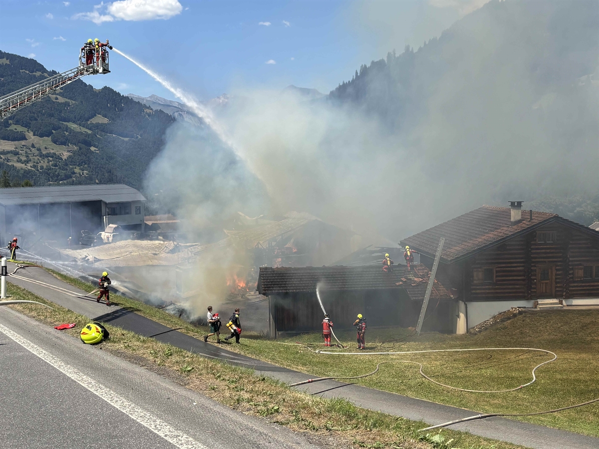Übersichtsaufnahme: Die Feuerwehr ist bei den Löscharbeiten und auf der linken Siete ist die Hebebühne.