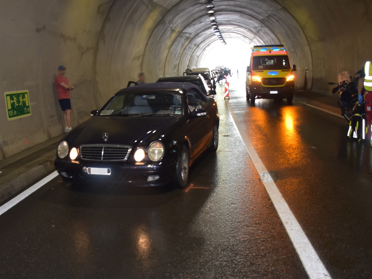 Aufnahme im Tunnel. Links mehrere Fahrzeuge. Rechts ein Motorrad und ein Rettungswagen.