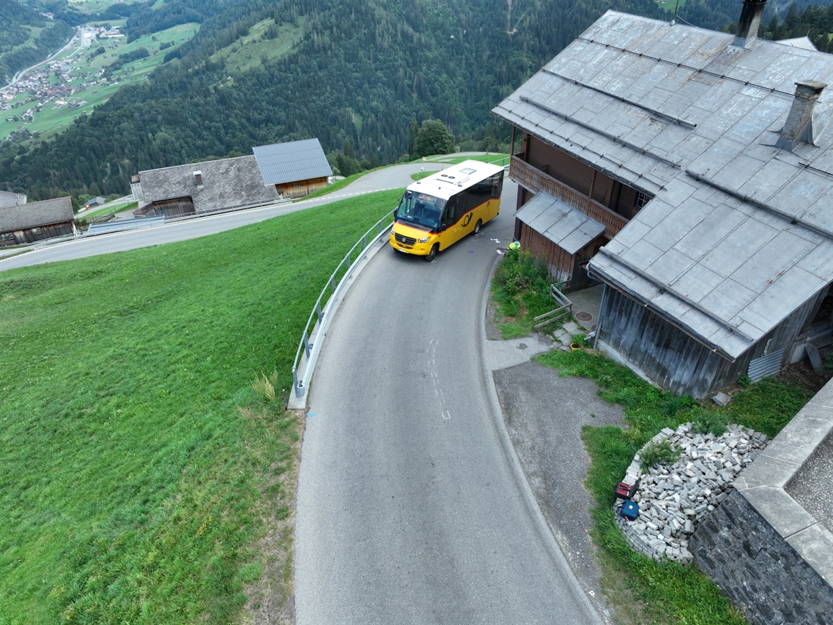 Postauto im Kurvenbereich in Furna, Ortsbereich Chilcha