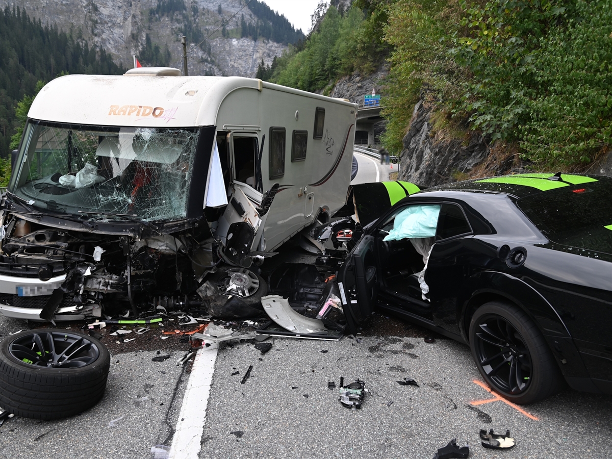 Die beiden Fahrzeuge – ein Wohnmobil und ein Auto – nach der Frontalkollision auf der Italienischen Strasse ineinander verkeilt. Überall liegen Fahrzeugteile auf der Fahrbahn verstreut