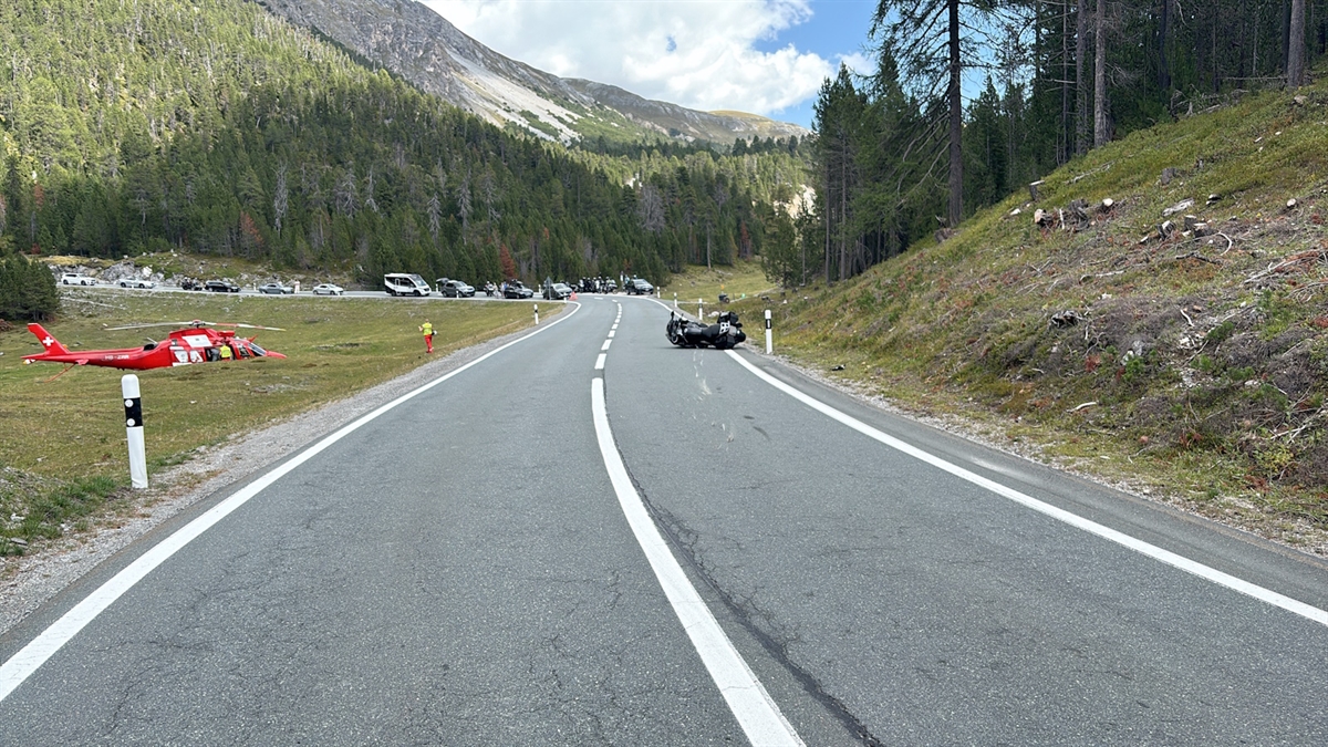 Die Ofenbergstrasse, mittig im Bild das Motorrad auf der Seite liegend. Links im Bild die Rega und dahinter eine Autokolonne.