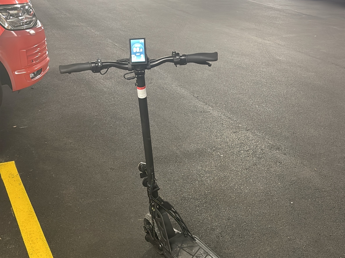 Der Roller von schräg oben. Links davon die Front eines Polizeiautos.