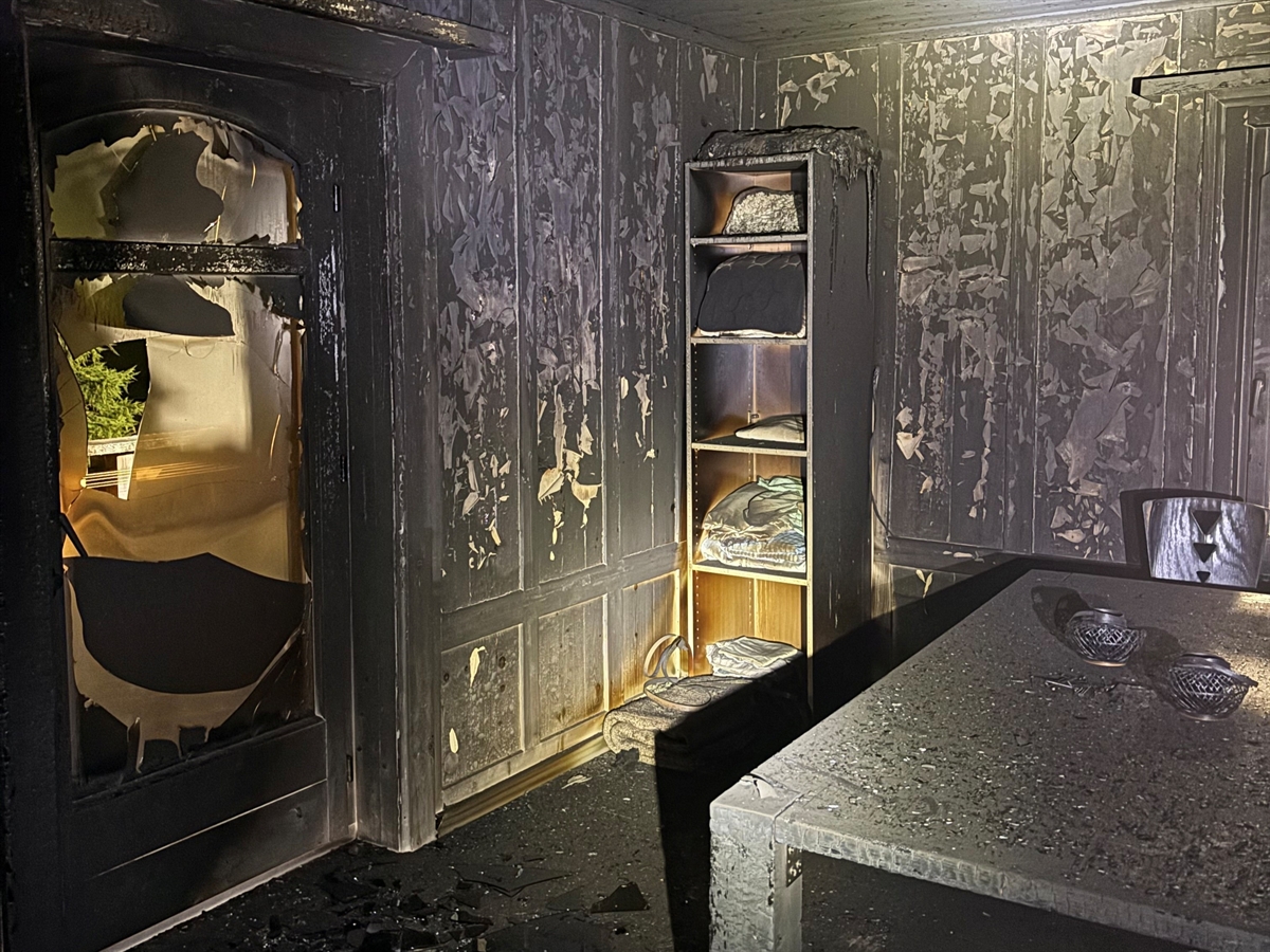 Ein vollständig ausgebranntes Zimmer. Die Wände weisen Holzverkleidungen auf.