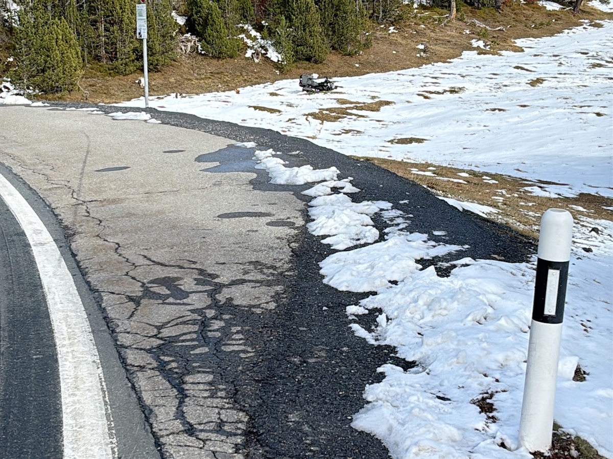 Das Motorrad liegt in der mit Schnee bedeckten Wiese am Fusse eines Waldrandes.