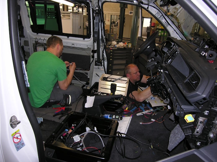 Zwei Männer beim Innenausbau eines Dienstfahrzeugs.
