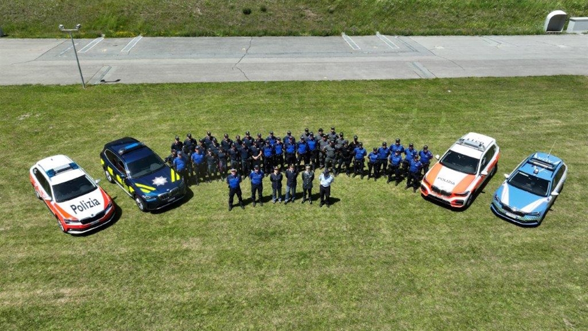 Drohnenaufnahme auf Teilnehmer und jeweils ein gekennzeichnetes Fahrzeug ihrer Institutionen.