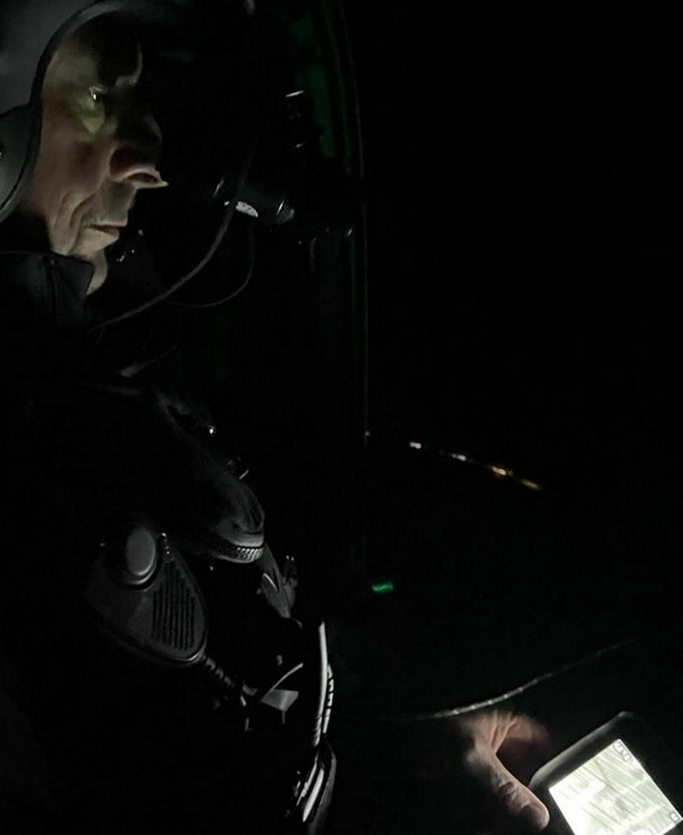 Ein FEL sitzt in der Nacht in einem Helikopter und kontrolliert über das Nachtsichtgerät die Umgebung. In der Hand hält er die Wärmebildkamera