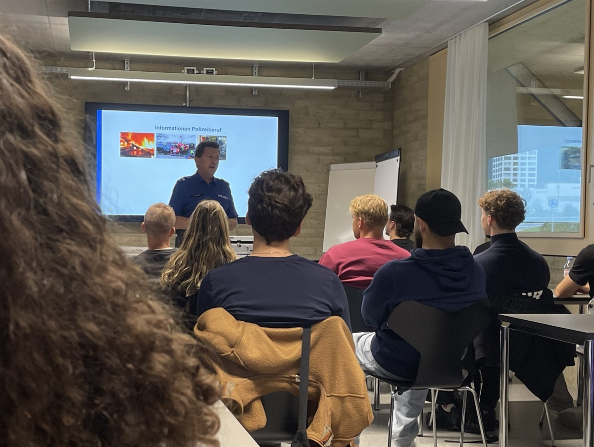 Ein Polizist vermittelt den Zuhörenden Wissenswertes über den Polizeiberuf.