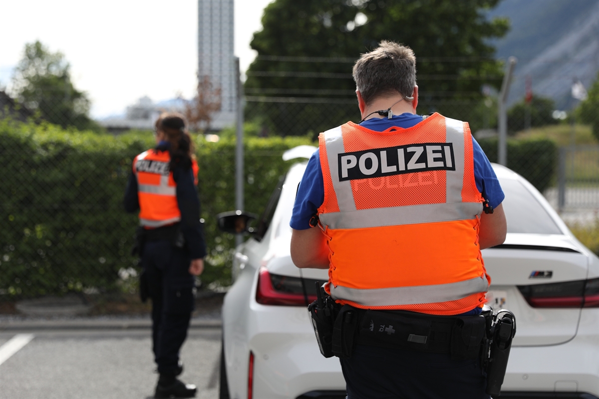 Eine Polizistin und ein Polizist bei der Kontrolle eines Autos