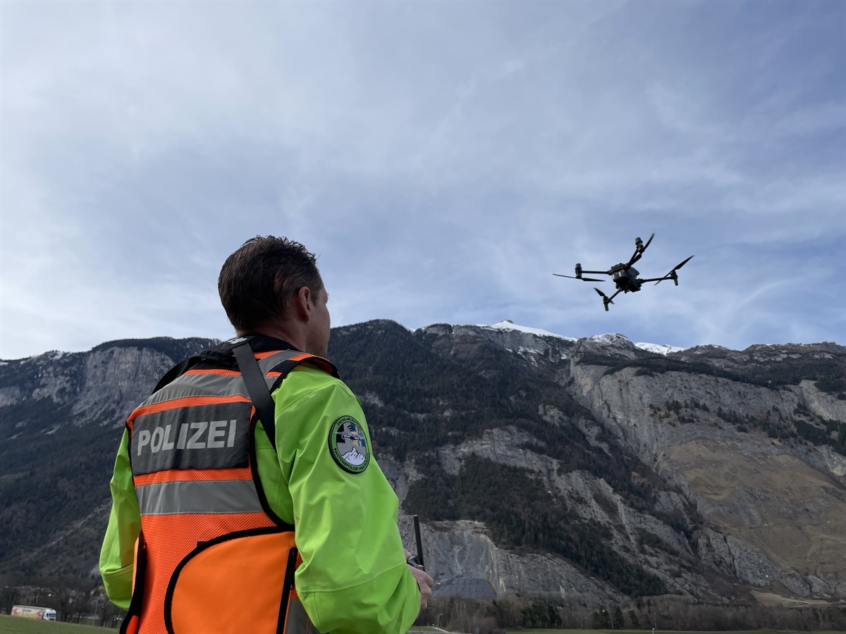 Drohnenpilot in Weste steuert Drohne am Himmel