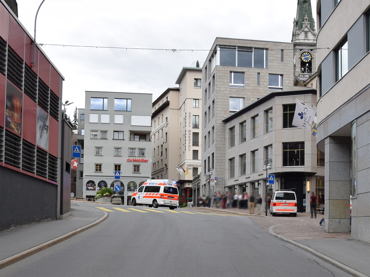 Aufnahme der Unfallstelle an der Plazza da Scoula in St. Moritz. Beim Fussgängerstreifen steht ein Ambulanzfahrzeug der Rettung Oberengadin sowie ein Patrouillenfahrzeug der Kantonspolizei Graubünden.
