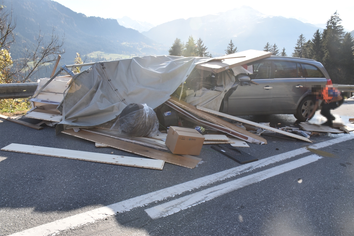 Stark beschädigter Personenwagen, herumliegende Möbel