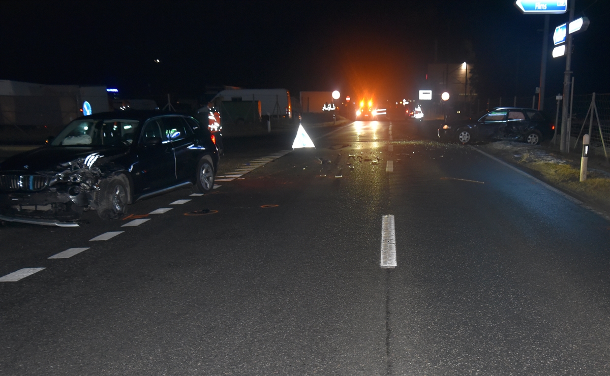 Zwei total beschädigte Fahrzeuge teils neben der Fahrbahn in der Dunkelheit