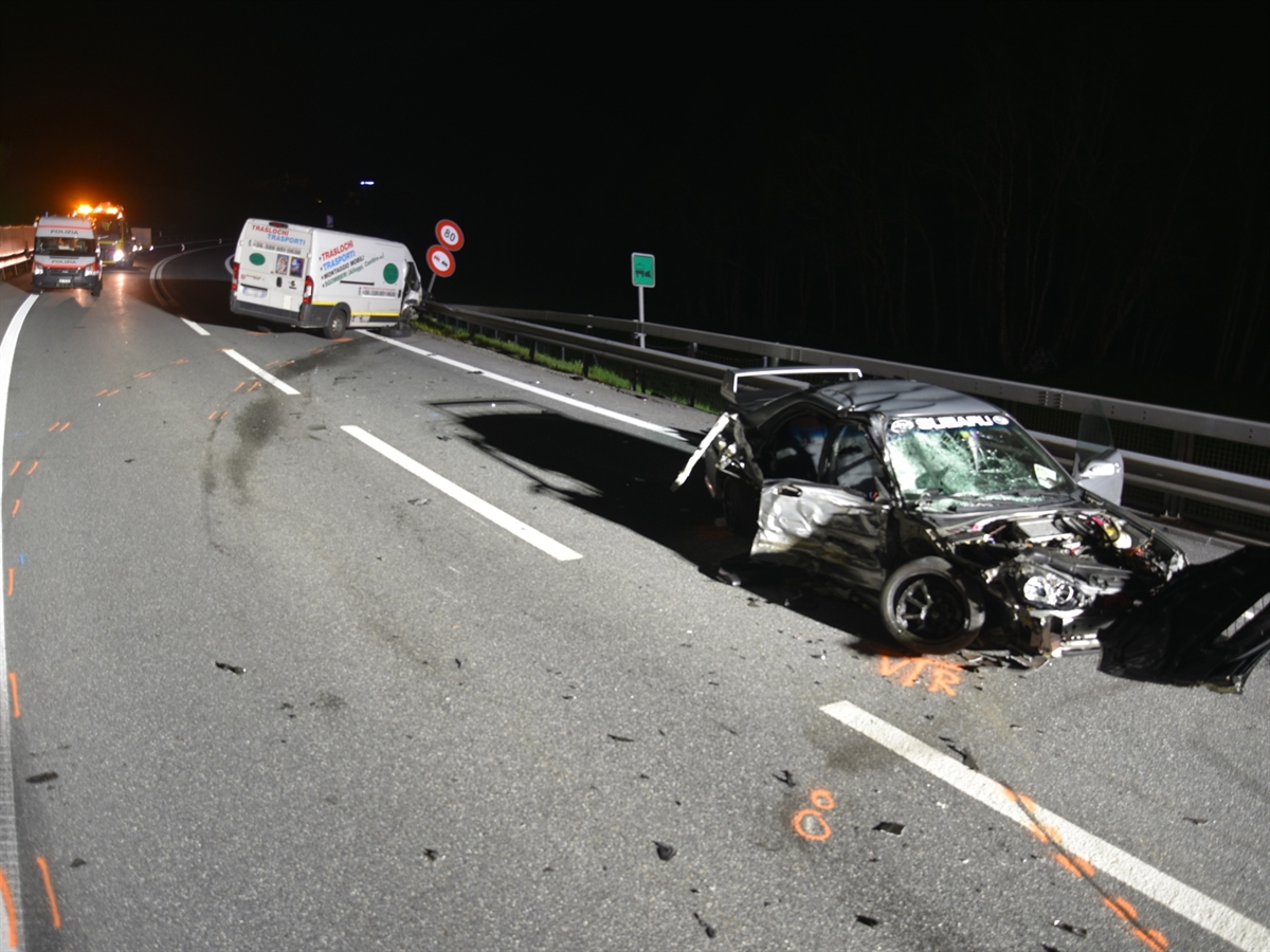 Autostrasse bei Nacht. Auf der rechten Fahrspur das total beschädigte Auto des 20-Jährigen. Im Hintergrund der Lieferwagen sowie ein Einsatzfahrzeug der Polizei. Hinter diesem der Abschleppdienst