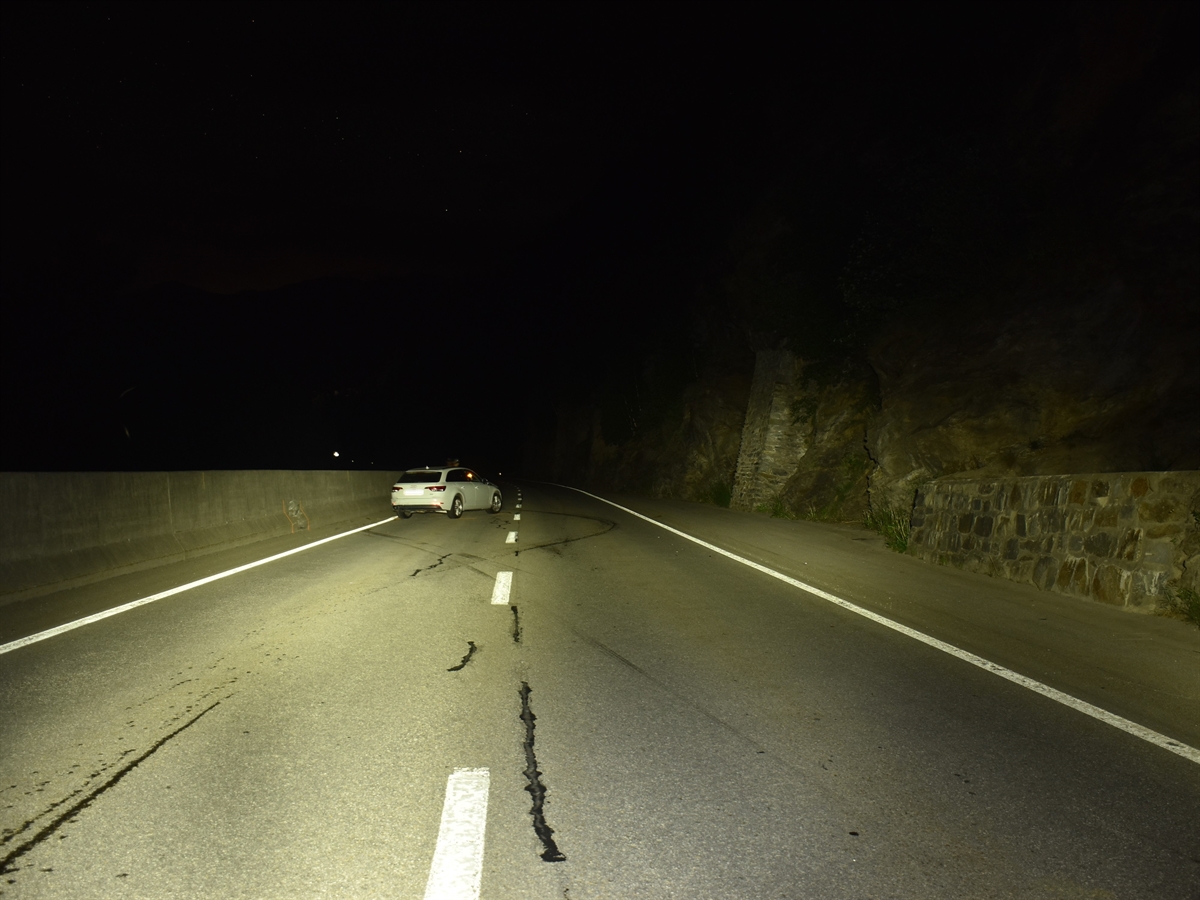 Nachtaufnahme. Das Auto welches mit den Betonelementen kollidierte steht beschädigt auf der Strasse. Kollisions- und Schleuderspuren auf der Fahrbahn.