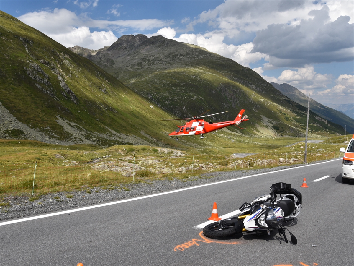 Auf der Fahrbahn liegt das verunfallte Motorrad. Mitten in der schönen Bündner Berglandschaft hebt der Regahelikopter ab.