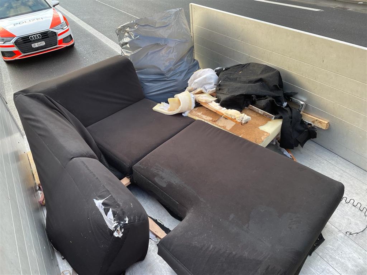 Beschädigte Möbelstücke auf einer Ladebrücke. Dahinter ein Polizeiauto.