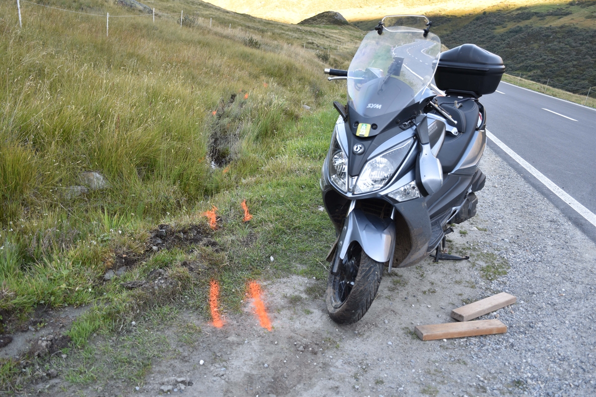 Roller steht neben der Strasse, orange eingezeichnet Unfallspuren im Gras