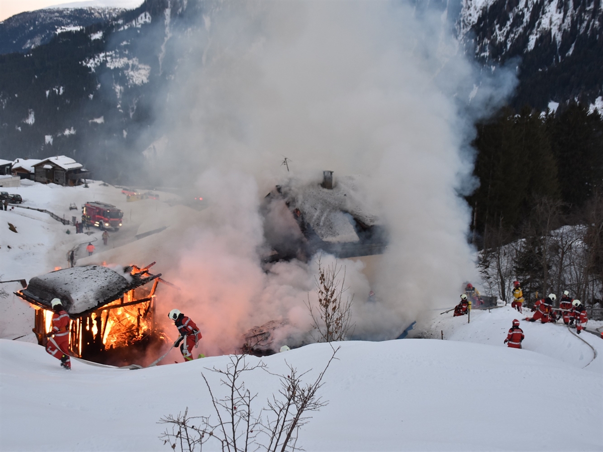 In der Winterlandschaft kämpfen mehrere Feuerwehrleute gegen den Stall in Vollbrand sowie das zum Teil brennende Wohnhaus.