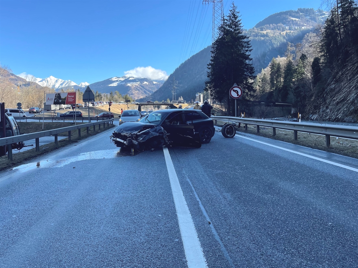 Das frontal stark beschädigte Auto steht mitten auf der Fahrbahn. Rechts von ihm sein vorne links abgerissene Rad.