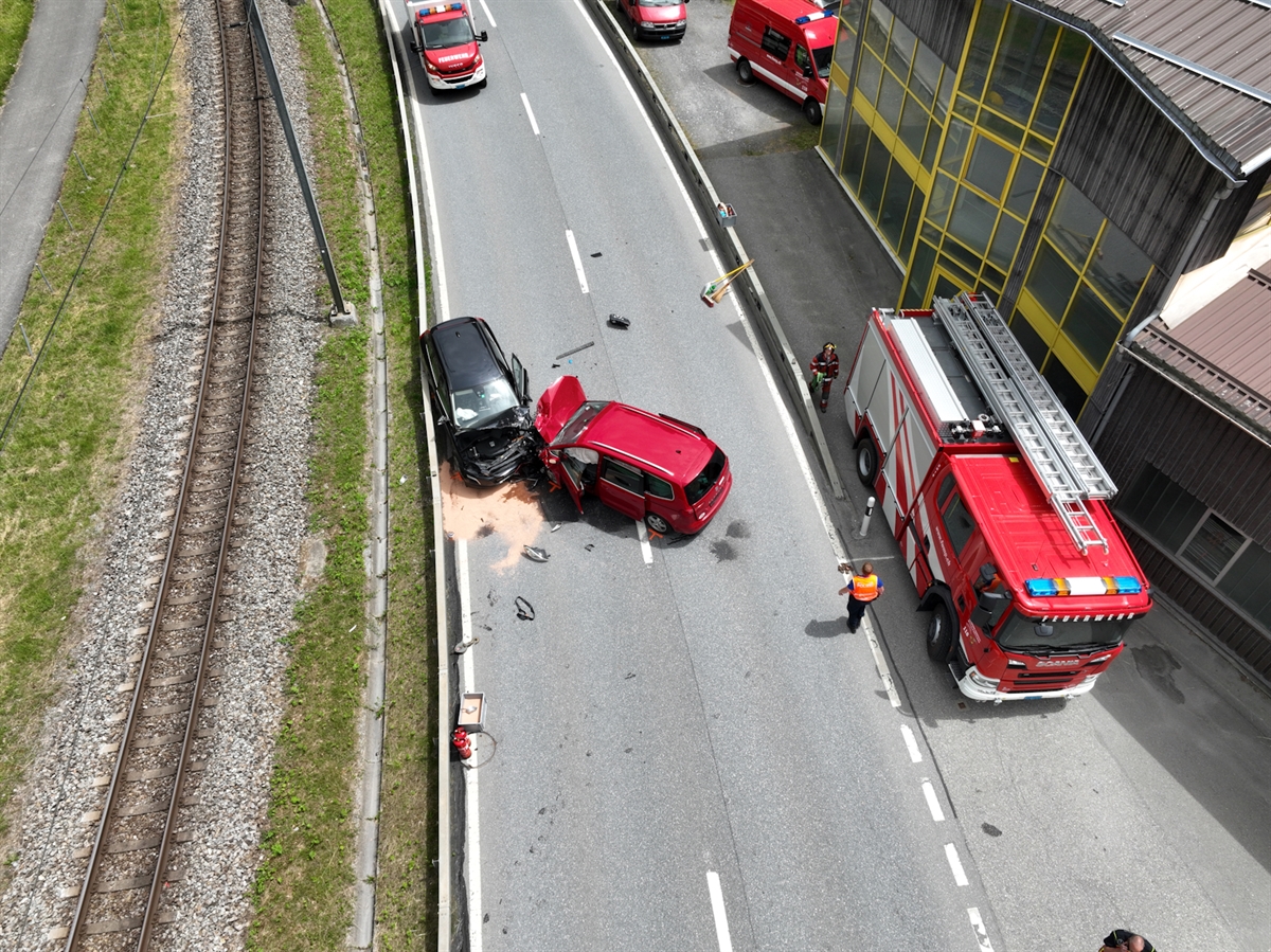 Drohnenbild mit der Fahrbahn. Das Auto des 65-Jährigen steht mit Front über die Gegenfahrbahn. Das Auto des 54-Jährigen steht eingeklemmt zwischen Leitplanke und dem anderen Auto ganz auf der Fahrspur in Richtung Landquart. Verschiedene Einsatzfahrzeuge der Feuerwehr sind ebenfalls auf dem Bild.