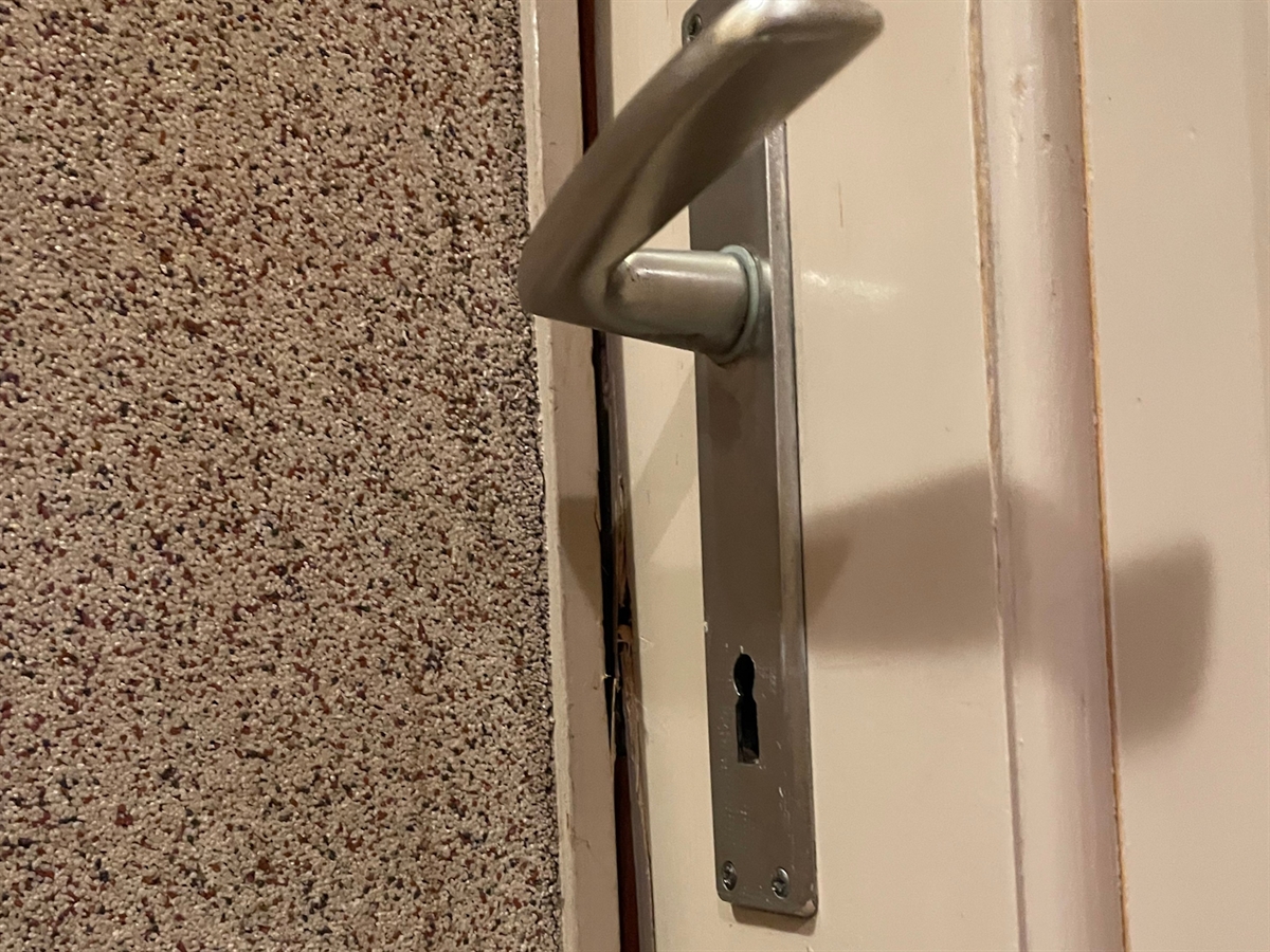 Eine Türe, bei welcher Einbruchspuren sichtbar sind.