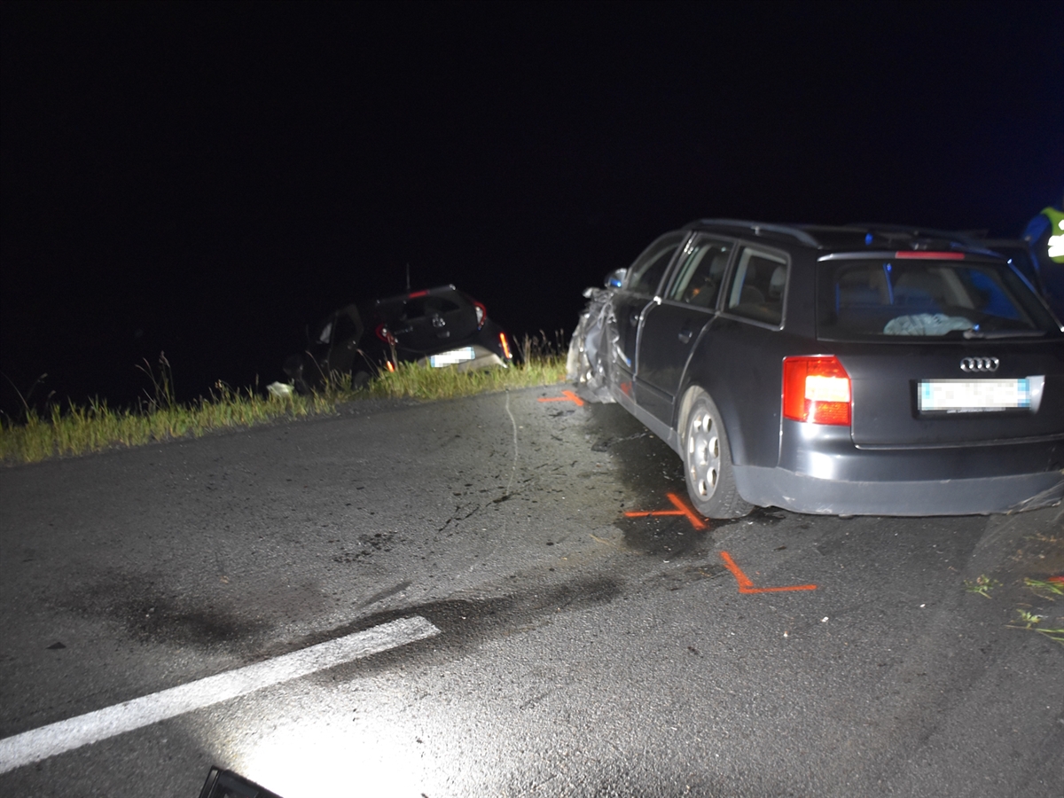 Das Auto der Frau steht quer zur Fahrbahn. In der Wiese neben der Fahrbahn ist das Heck des entgegenkommenden Autos erkennbar