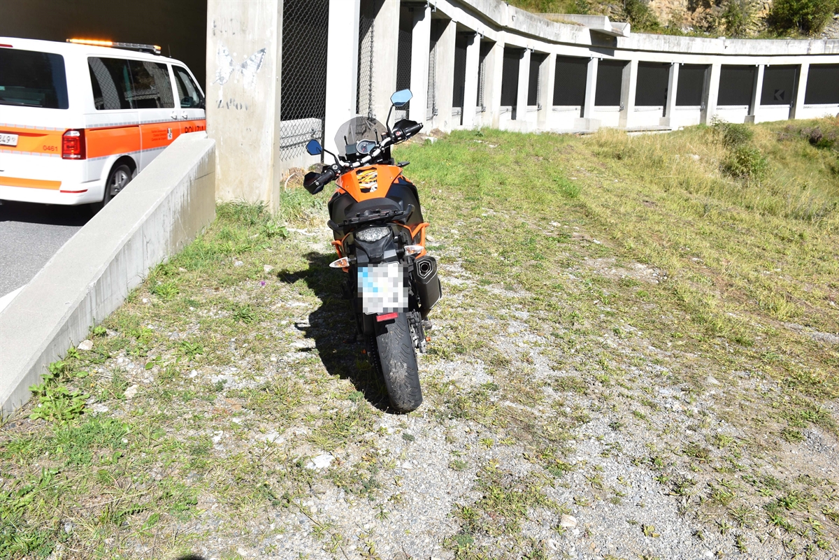 Motorrad in der Wiese ausserhalb der Galerie mit Polizeiauto